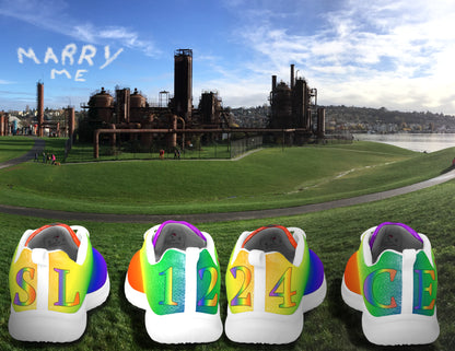 BFX rainbow pride athletic shoes with initials and wedding date in grass at Gas Works Park in Seattle with Marry Me written in the clouds above